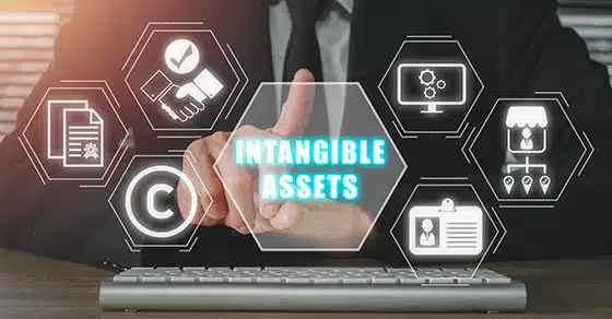 Intangible assets concept, Businessman hand touching intangible assets icon on virtual screen.